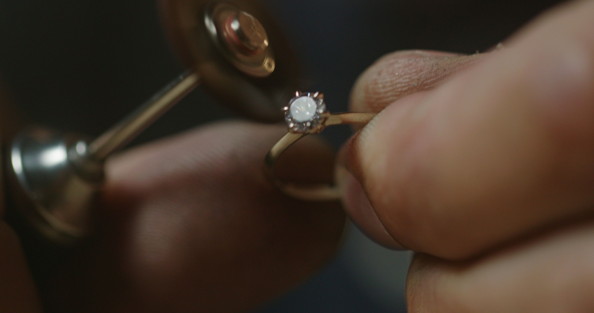 Extreme close up - a jeweler polishes a precious stone in a newly created ring